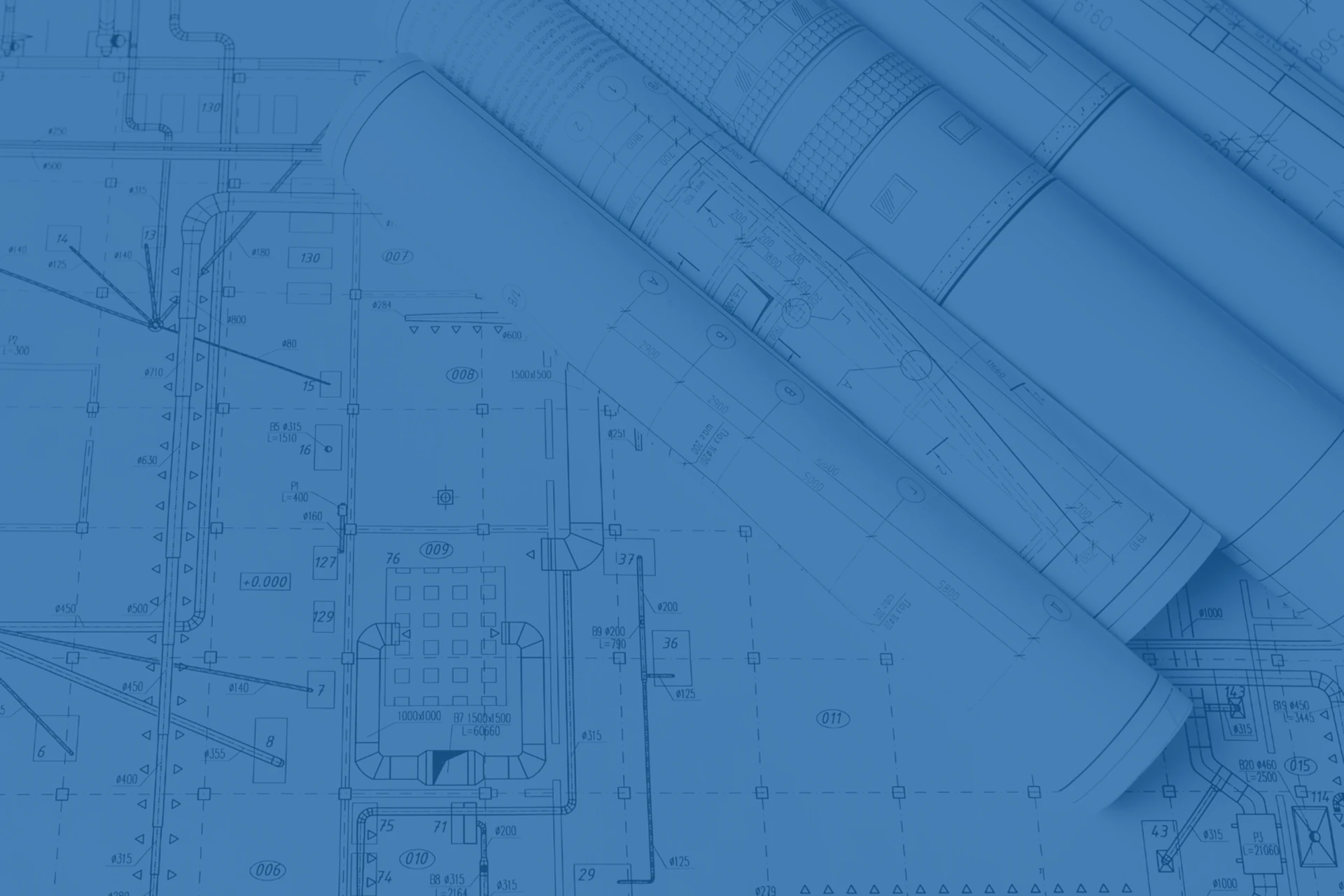 Imagen de varios planos de arquitectura abiertos y enrollados que muestran dibujos técnicos de delineación